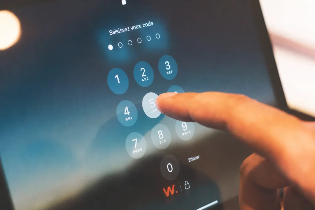 Un doigt saisit un code de vérification sur le pavé numérique d’une tablette.