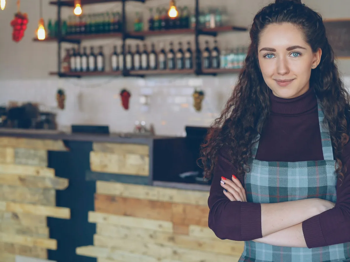 Jeune commerçante souriante dans son établissement