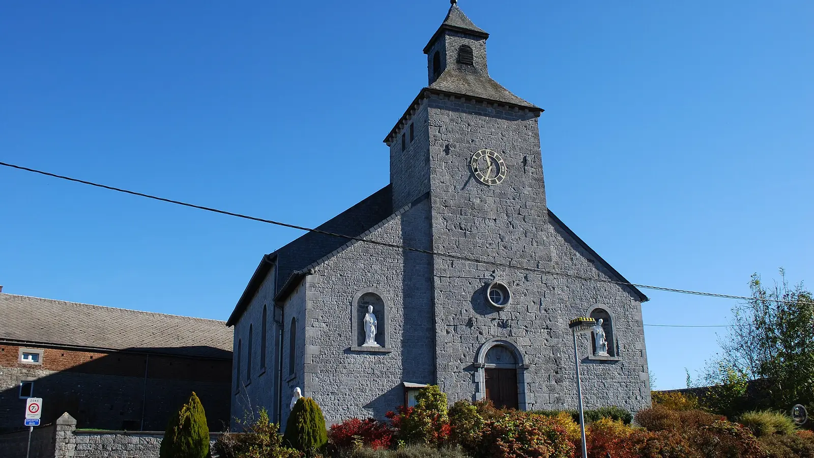 Église de Warzée dans la commune d’Ouffet sous un ciel bleu