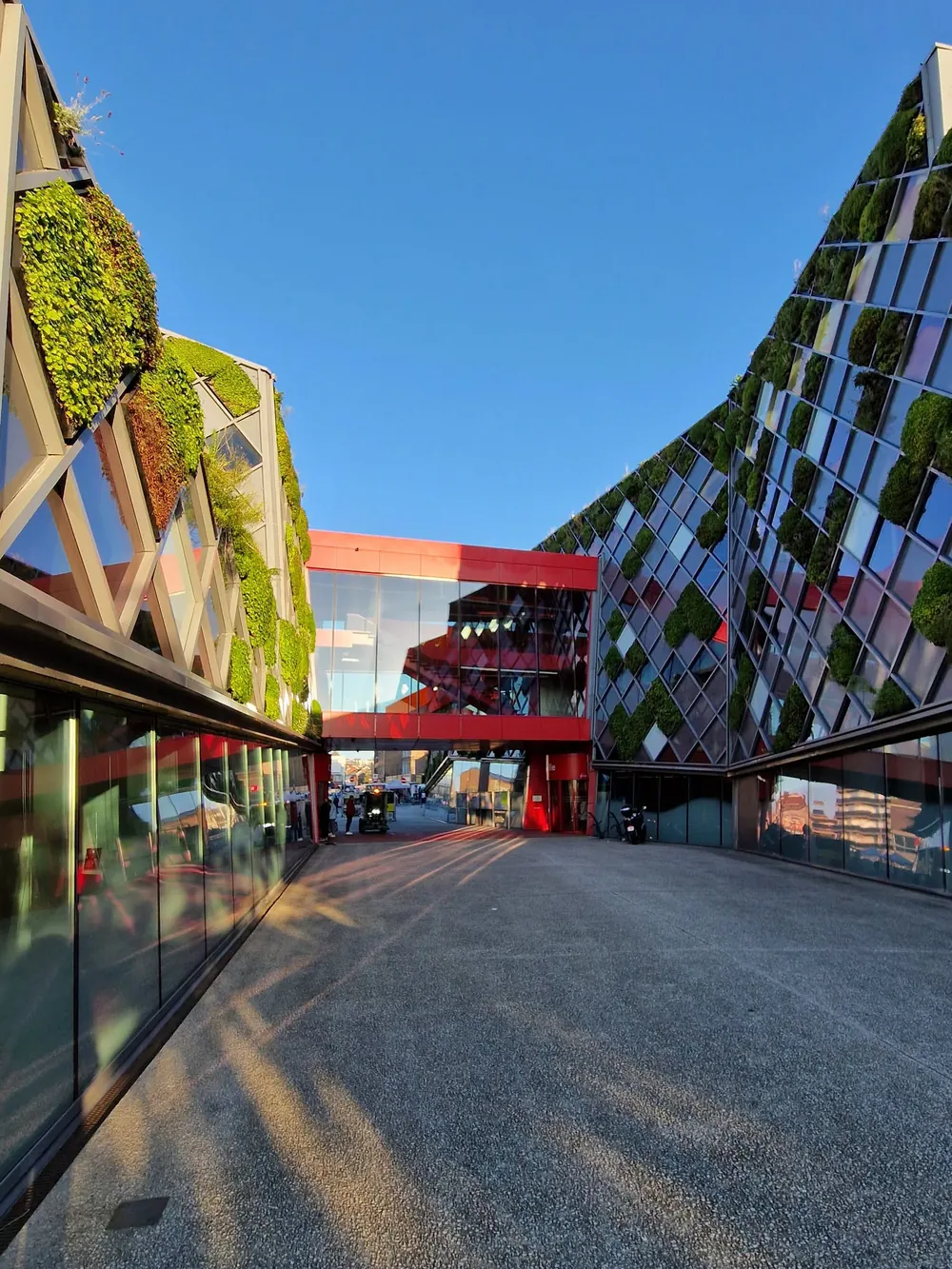 Architecture contemporaine végétalisée à Herstal sous un ciel bleu